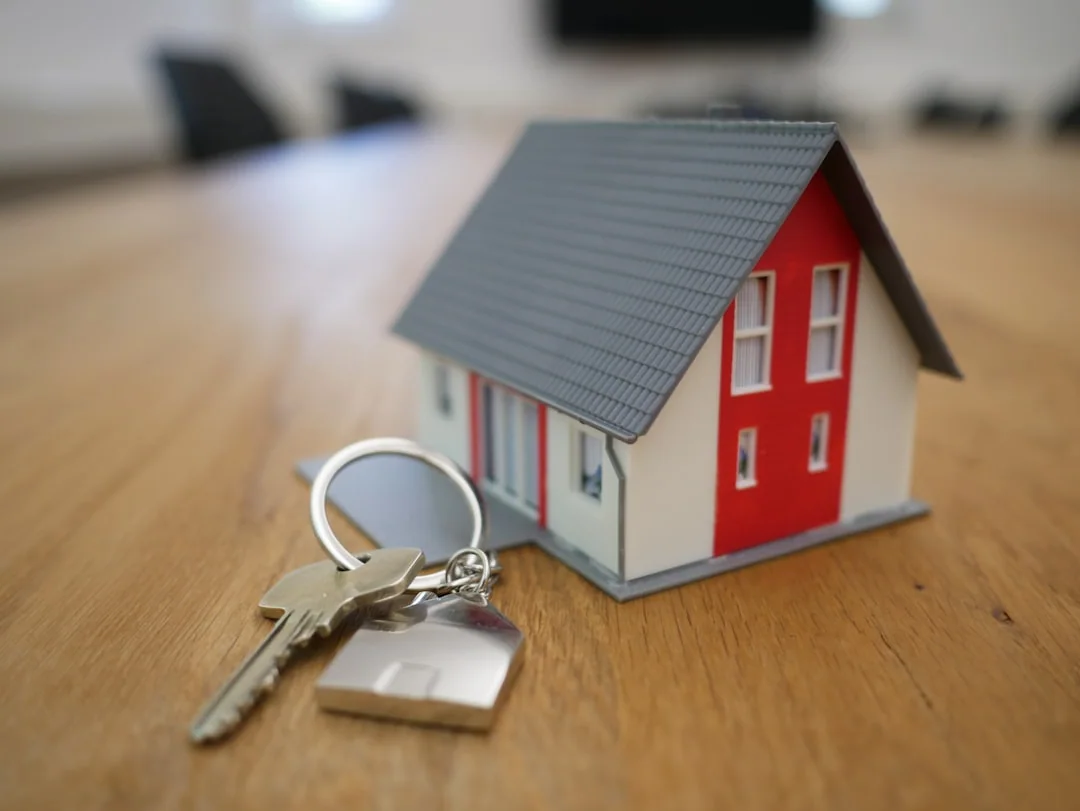House keys with a miniature home on a table